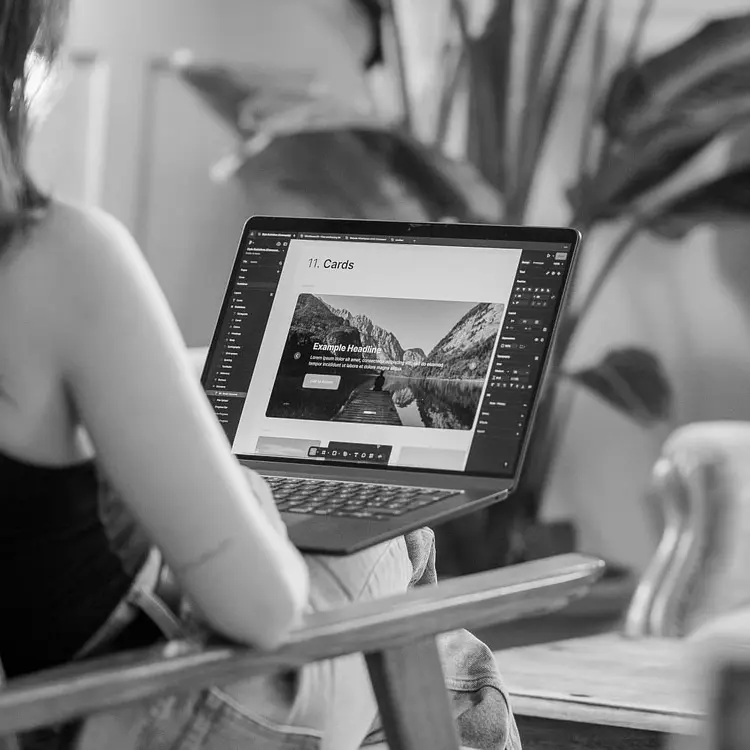 Schwarzweissfoto: Larissa Sequeira baut am Laptop eine Website, auf dem Bildschirm in Figma