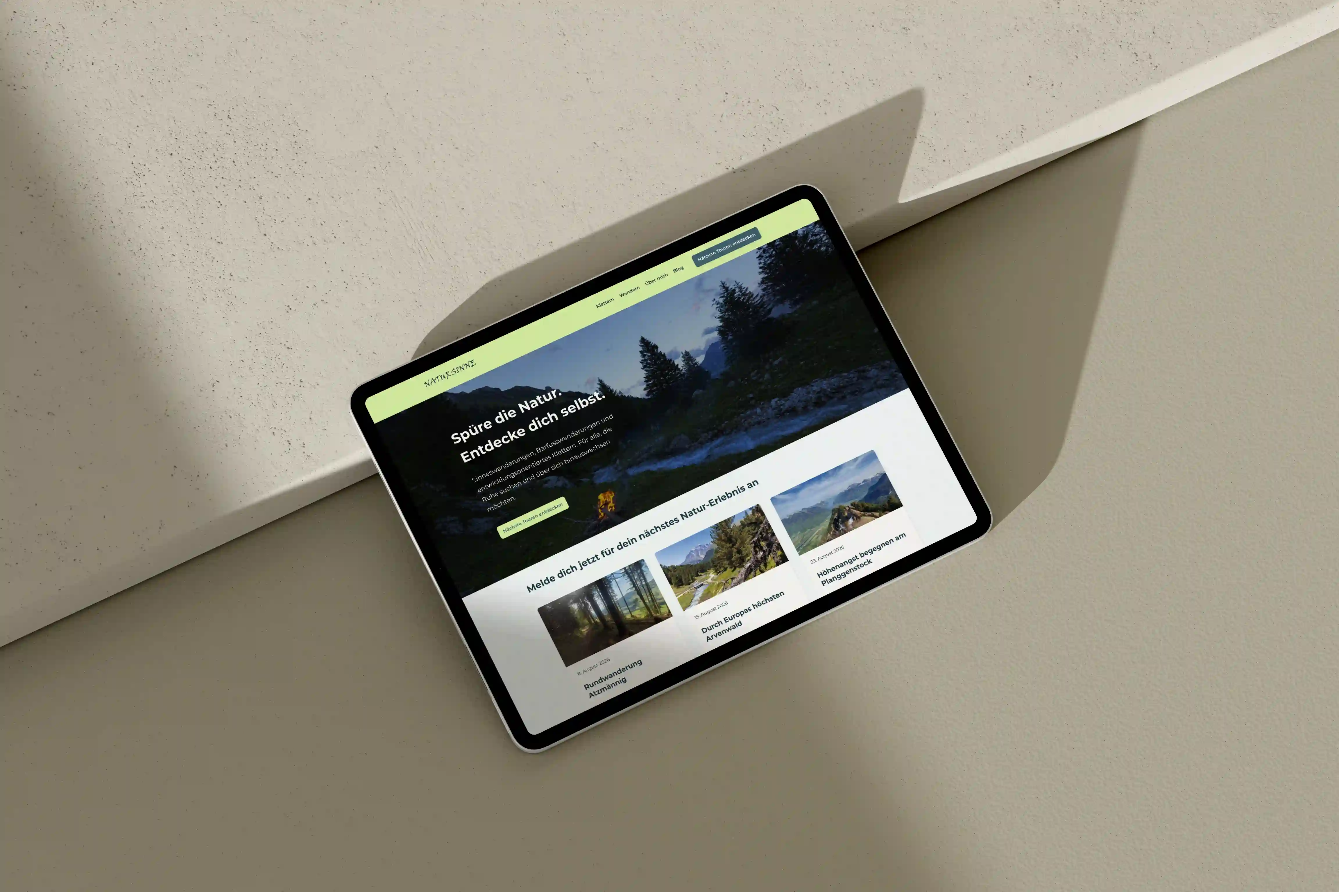 Die Website von Natursinne mit Waldbildern und grünem Menüband auf einem Tablet