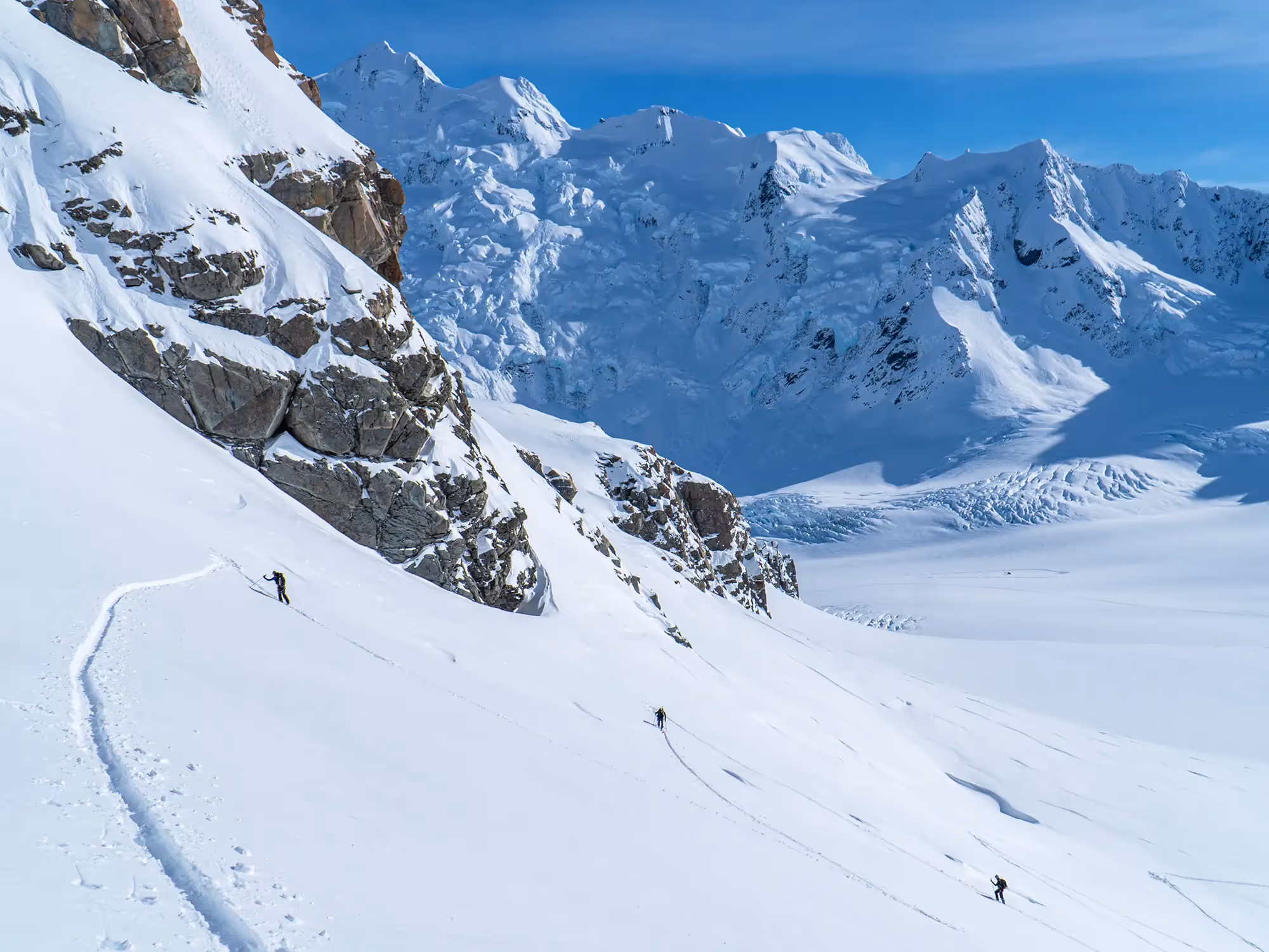 Deep powder ski trail with skiers below