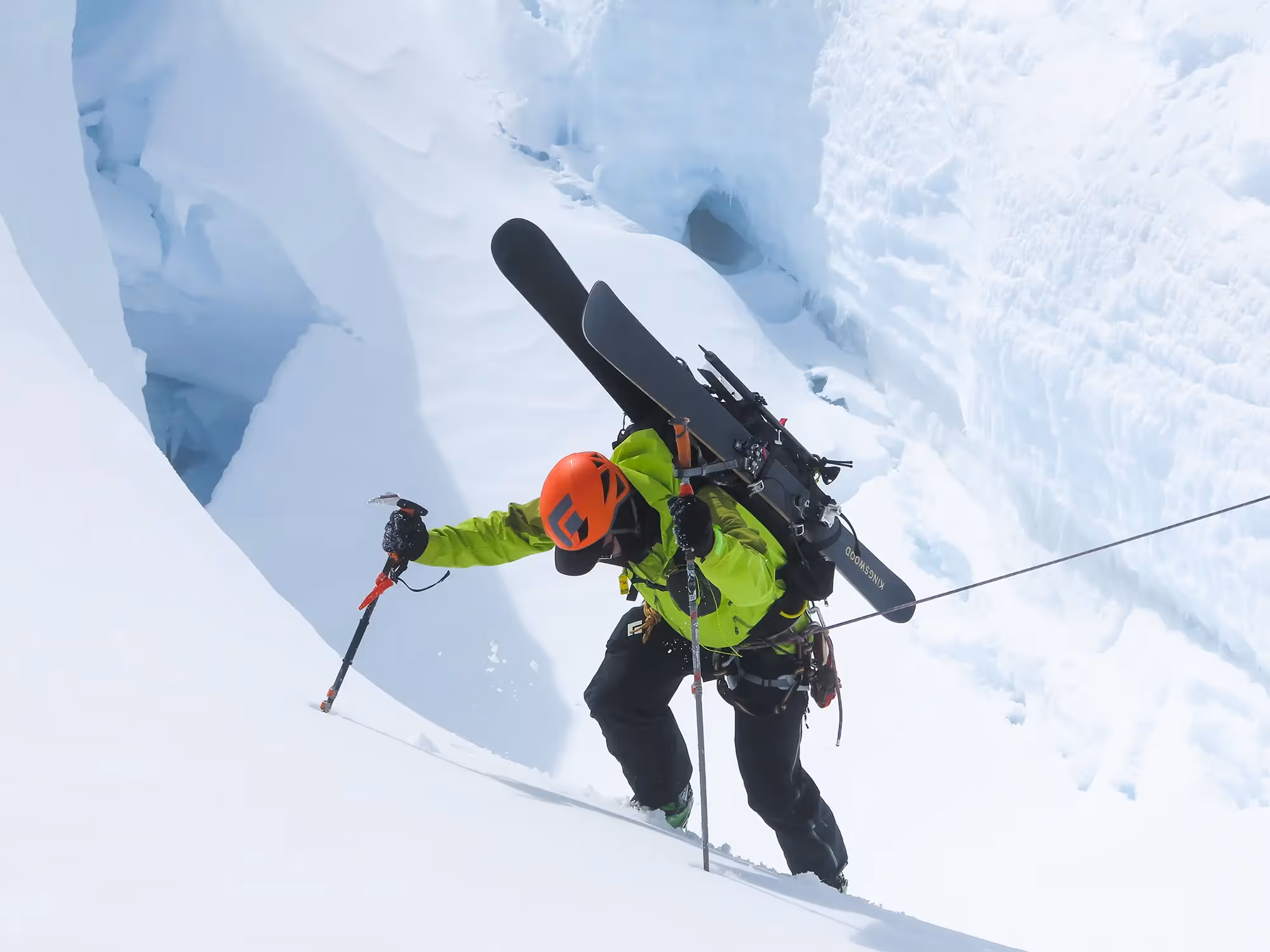 Ski Mountaineering Course skiers bootpacking uphill with skis on packs