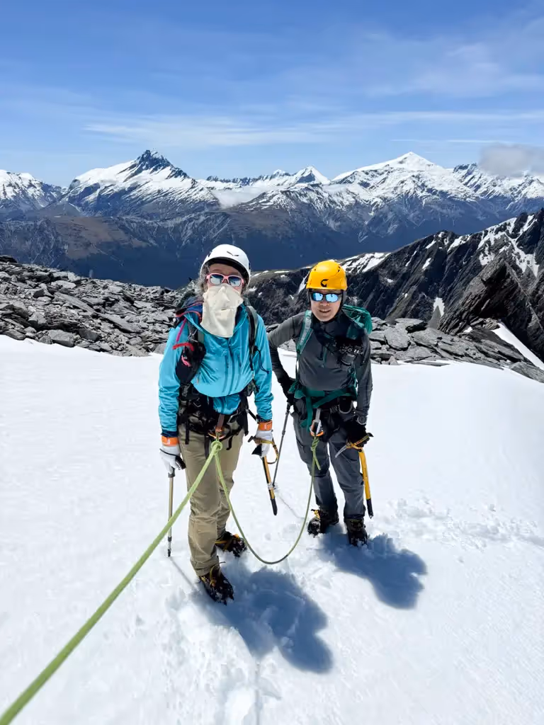 Two climbers roped together traversing snow ridge