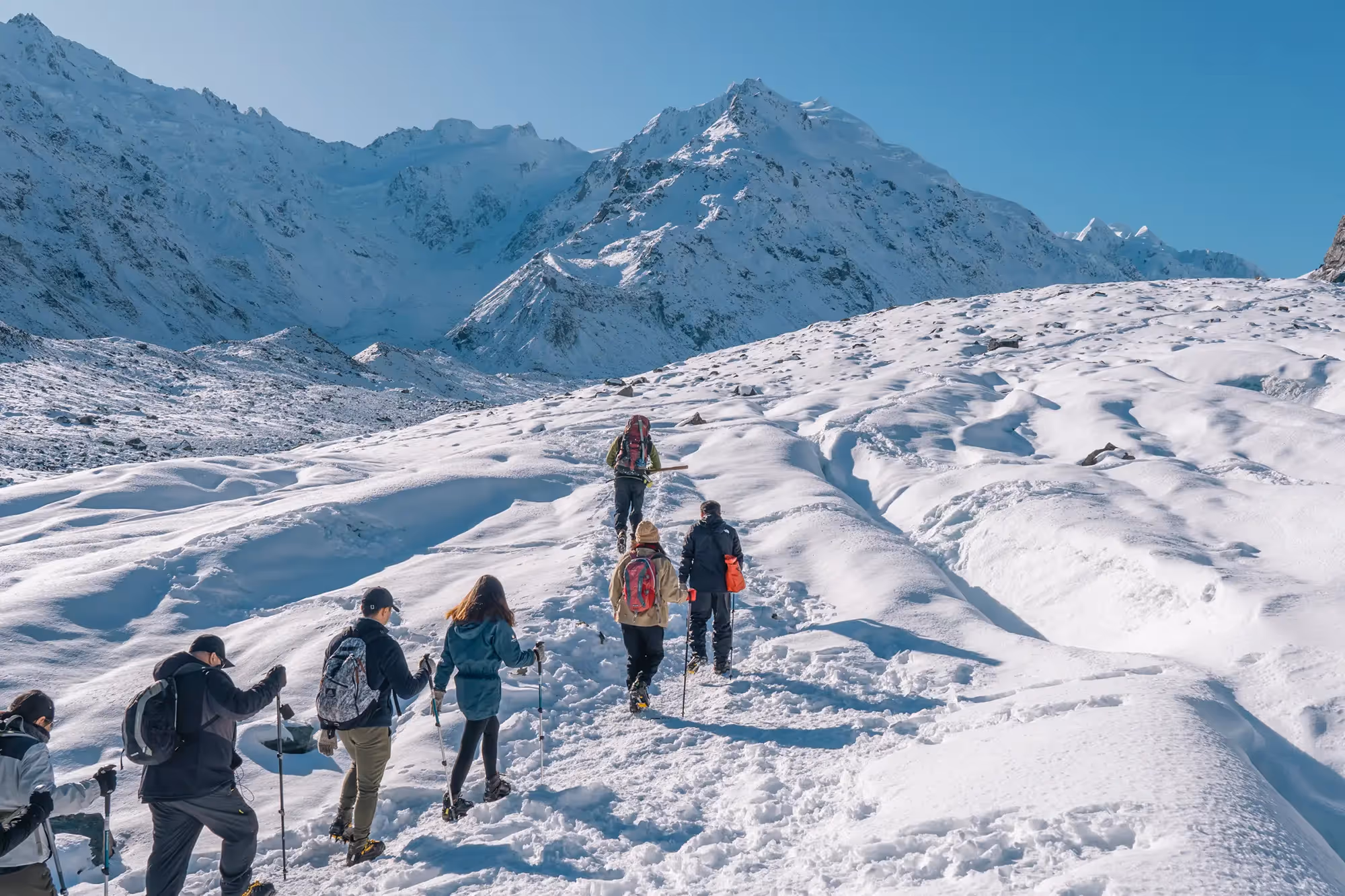 Guest following guide across glacier terrain
