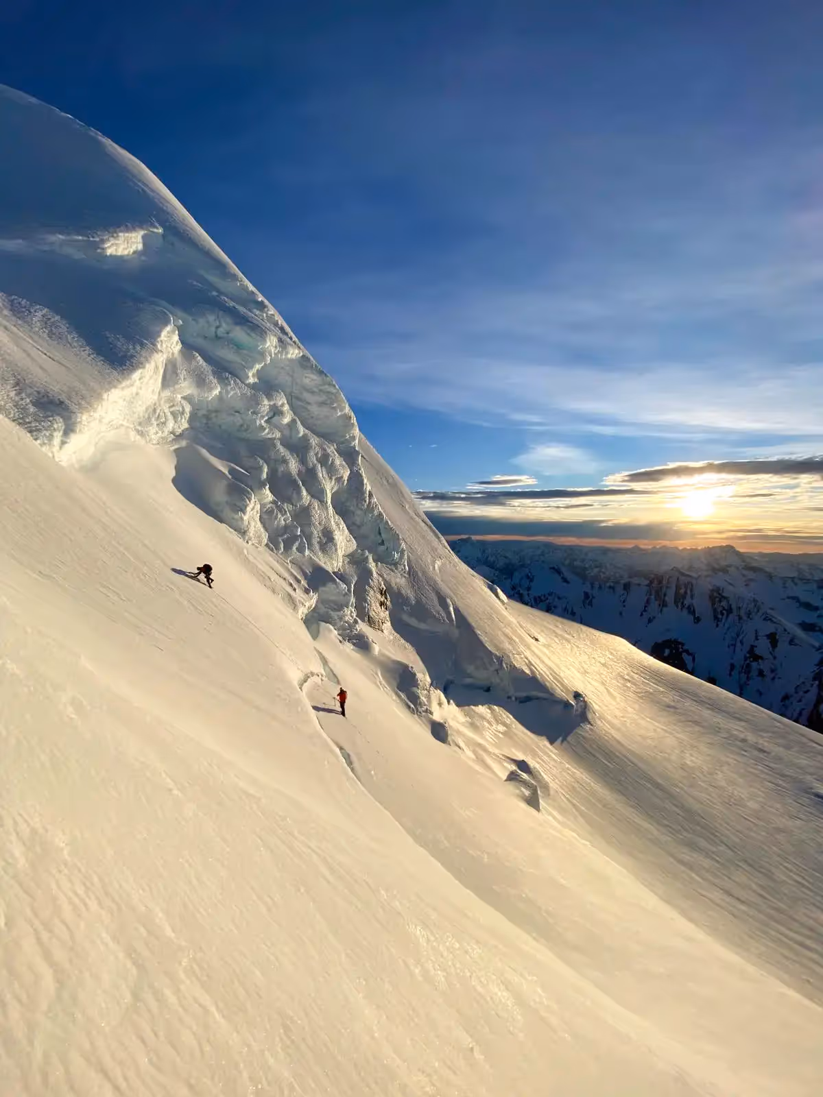 Hochstetter climber and guide ascending on snowy terrain early morning