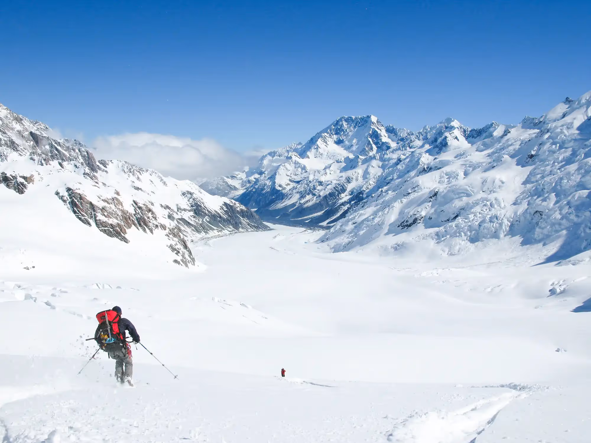 Two participants skiing down a glacier with views of Aoraki / Mount Cook