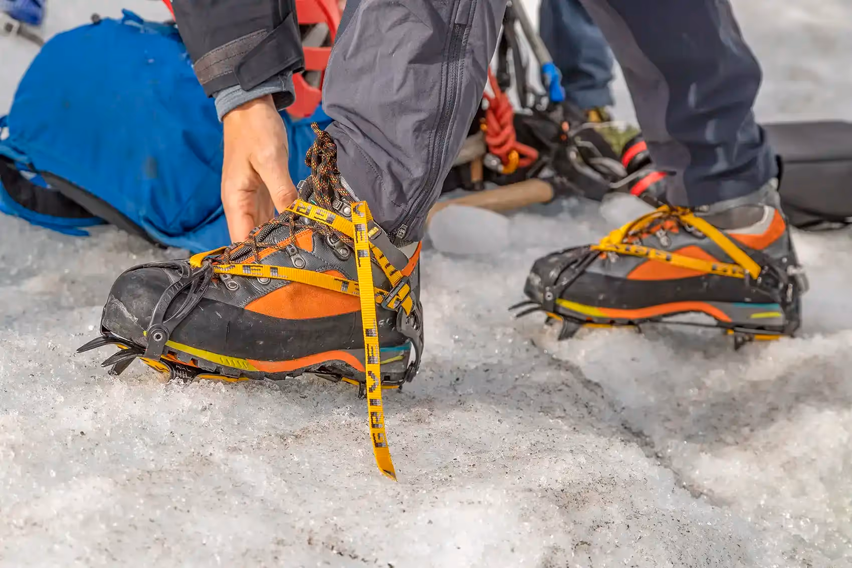 Guest putting on crampons on glacier