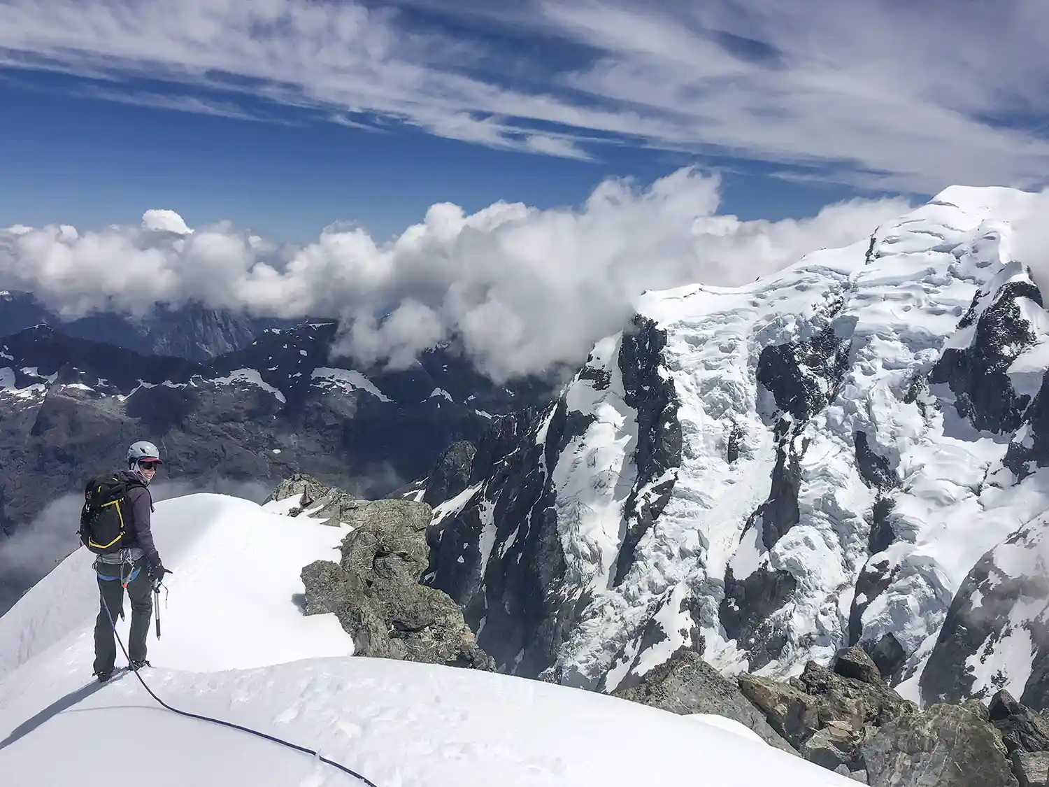 Roped climber descending snowy ridge