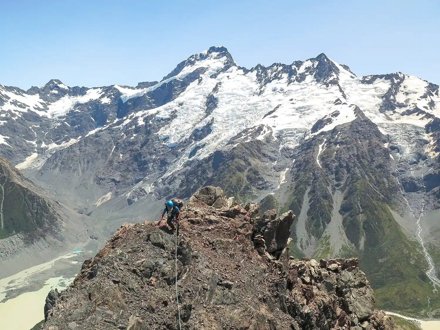 Climber on rocky peak. Mount Sefton on the background