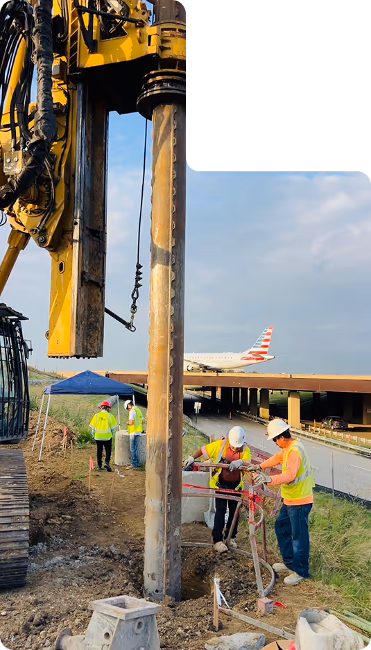 Large yellow excavator digging soil at a construction site during sunset.