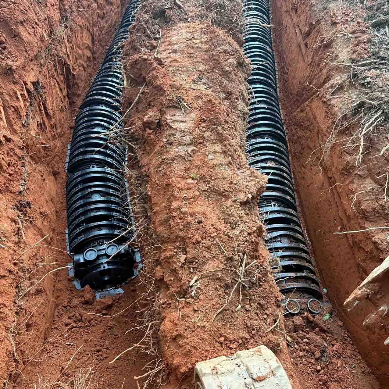 Drain field installation in north Georgia; corrugated drain lines laying in the ground, ready to be covered.