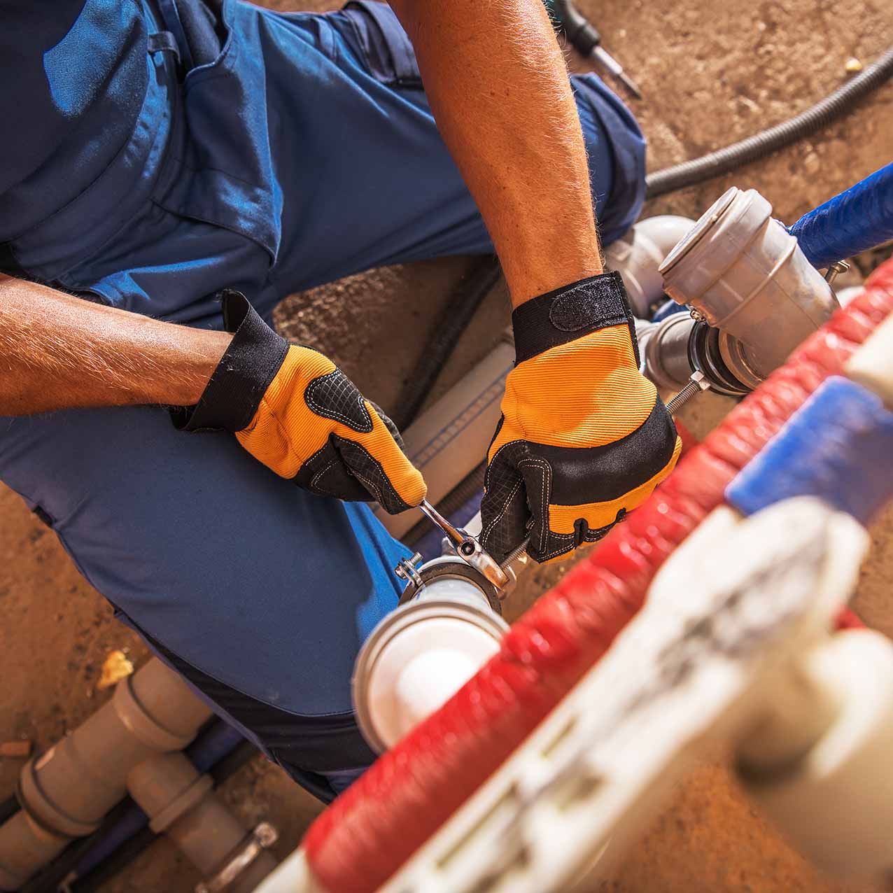 Pipe repair and replacement; plumbing in north Georgia. Top-down view of a man working on pipes.