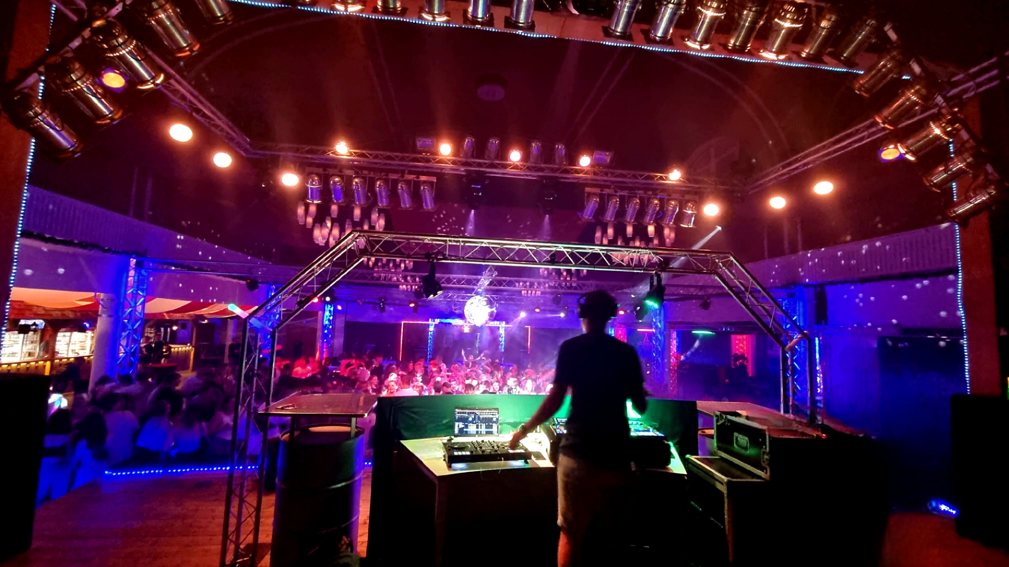 DJ Glen Haens an einem DJ-Pult vor dem Publikum in einer Veranstaltungshalle