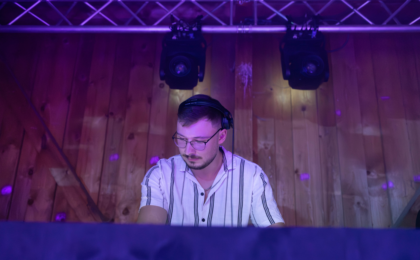 DJ Glen Haens beim konzentrierten Mixen unter violettem Clublicht