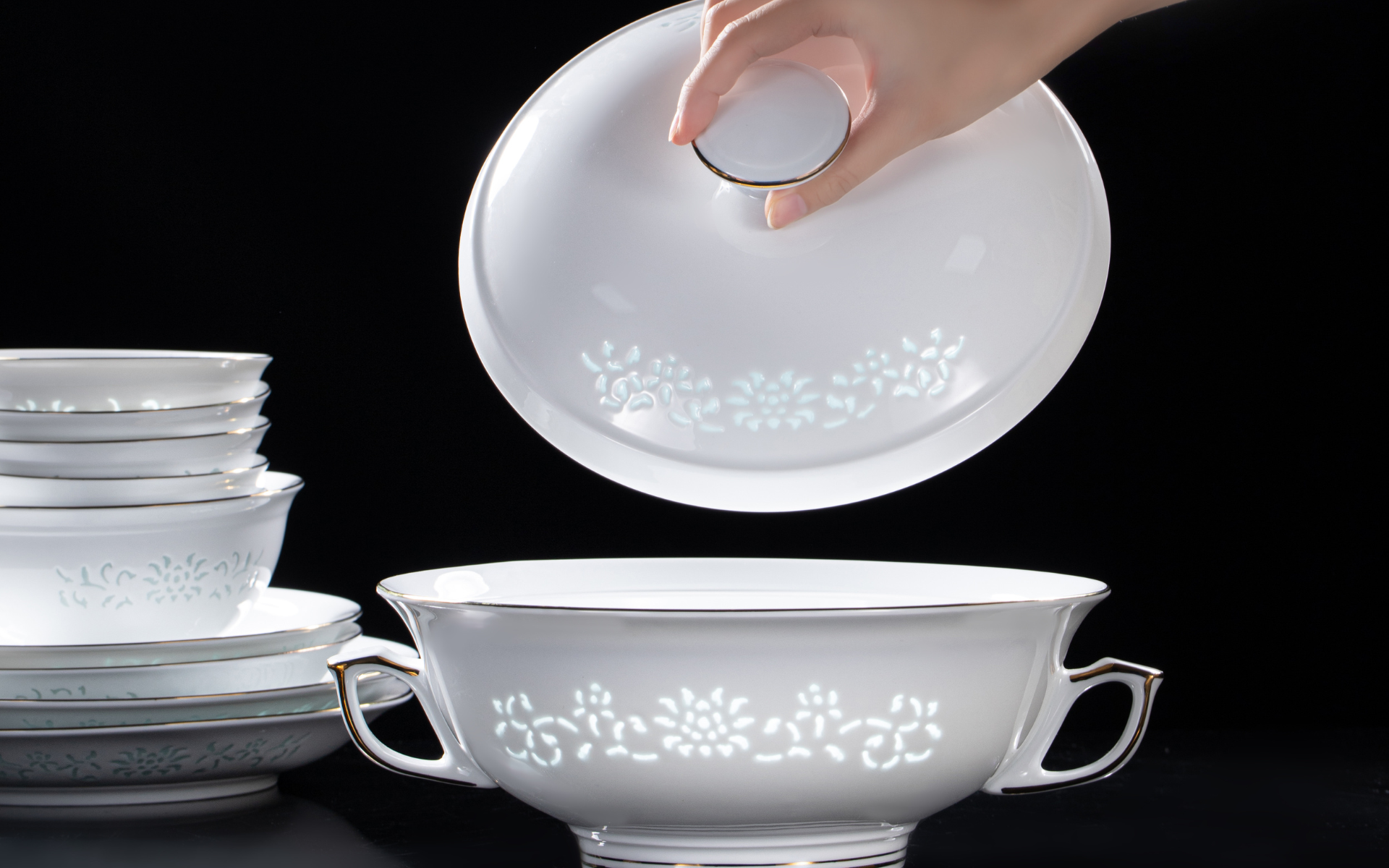 A hand lifting the lid of the Imperiax soup tureen