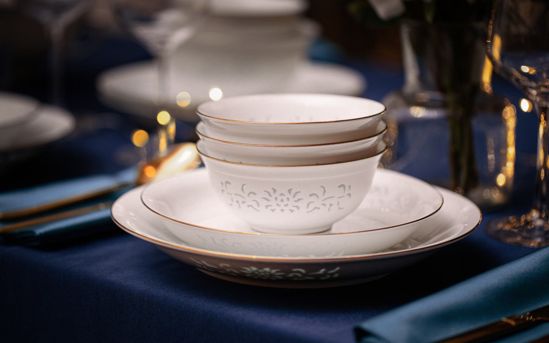 Imperiax place setting with stacked bowls and gold-rimmed plates