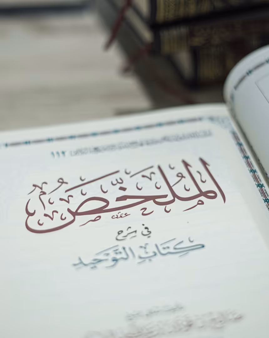 Open book page featuring Arabic calligraphy with bold decorative text at the center, likely a religious or classical text.