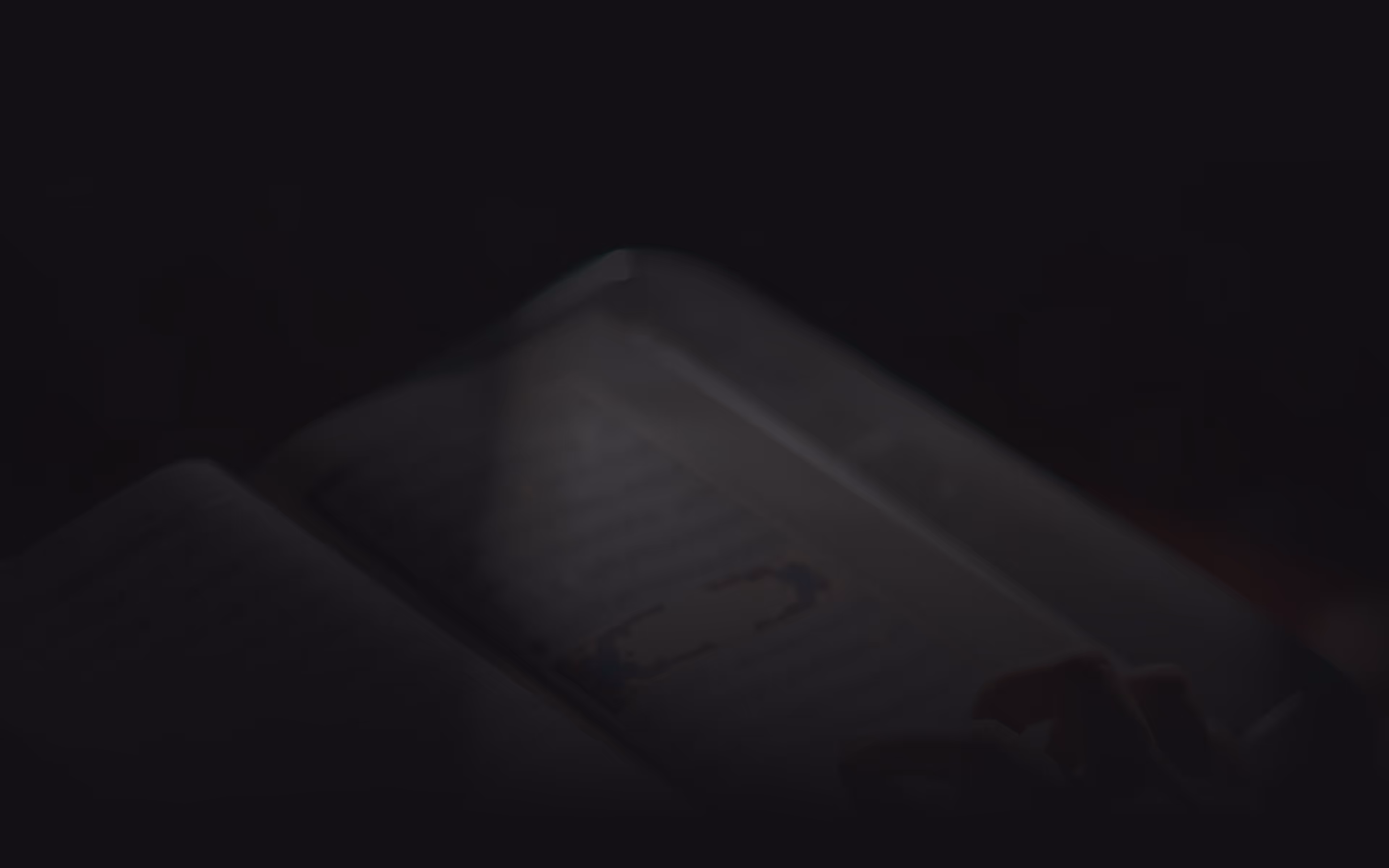 Open notebook with blank lined pages and a small paperclip on the right page, set against a dark background.