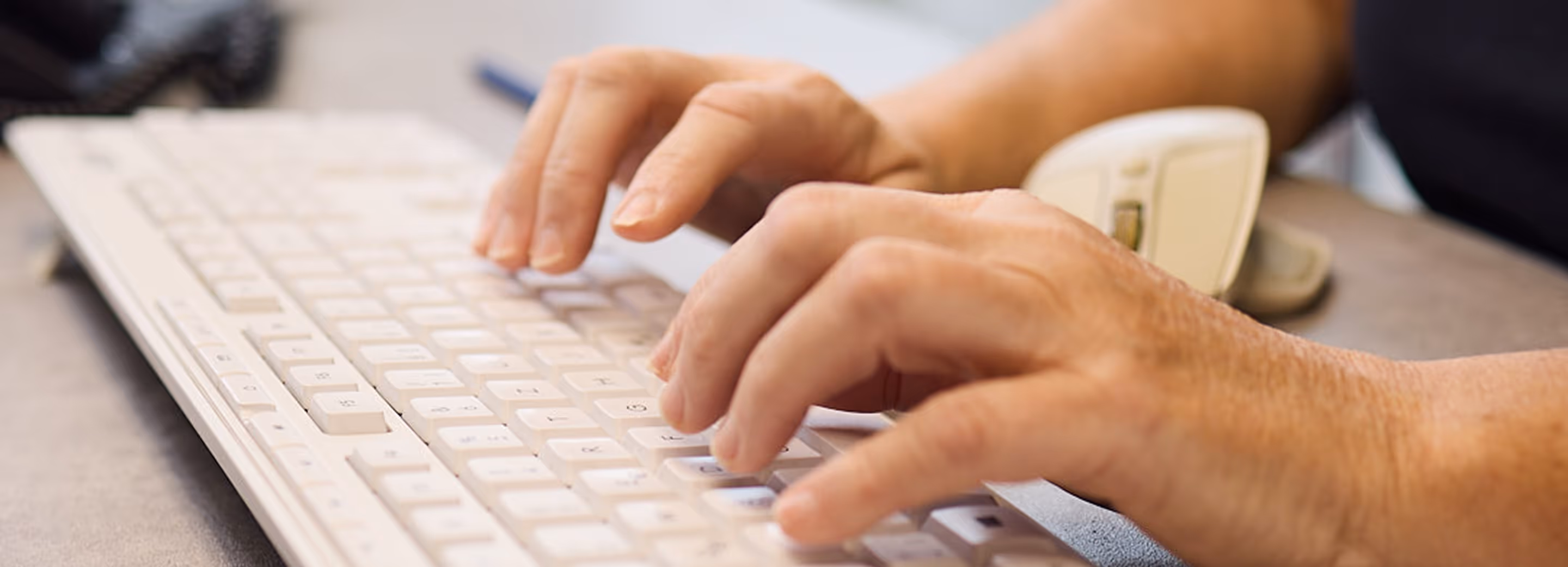 Im Bild sieht man die Hände eines Mitarbeiters der an einer Tastatur tippt