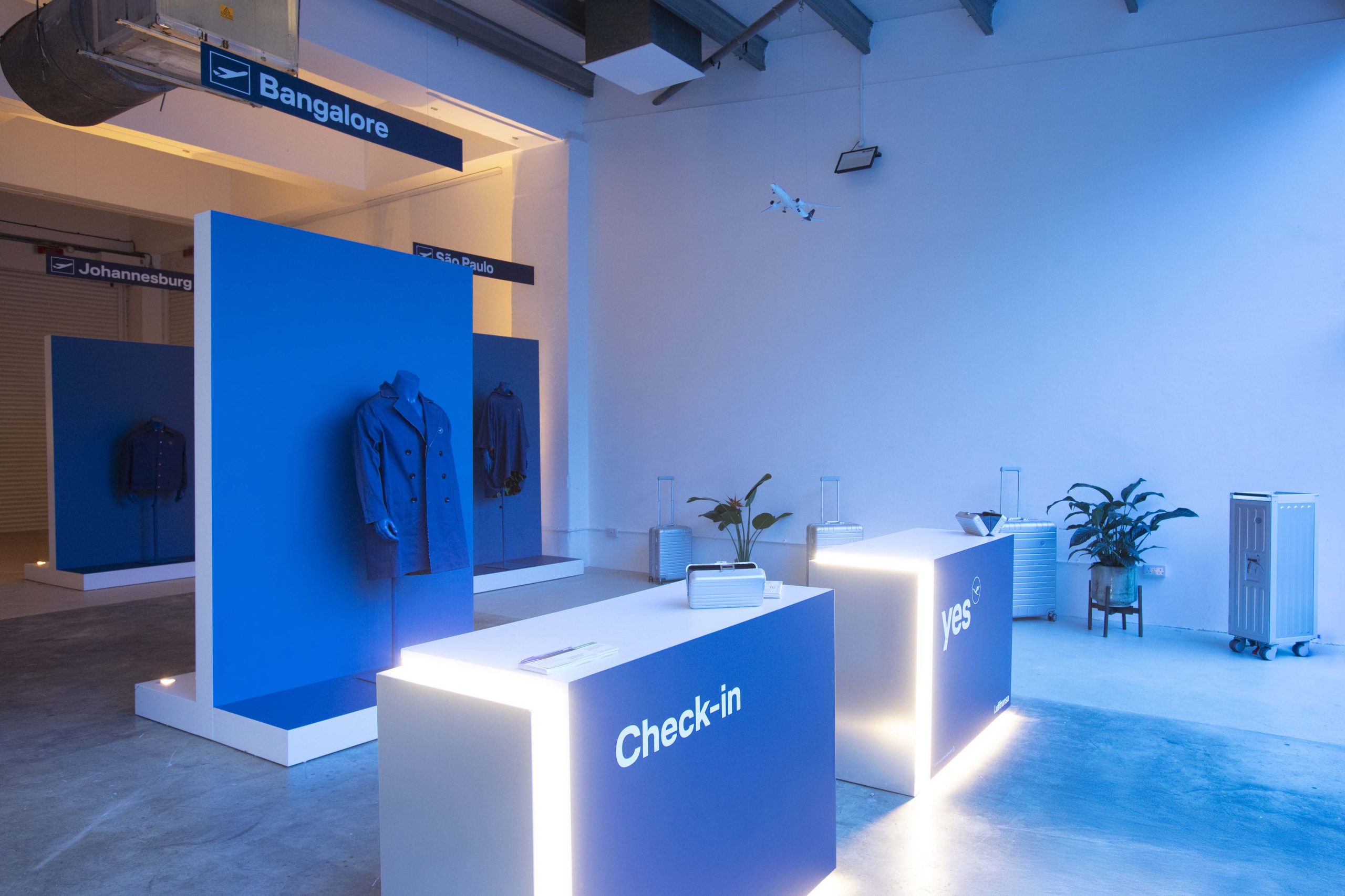 Airport terminal-inspired pop-up interior featuring check-in desks and destination gates for Bangalore, São Paulo, and Johannesburg with bespoke fashion displays
