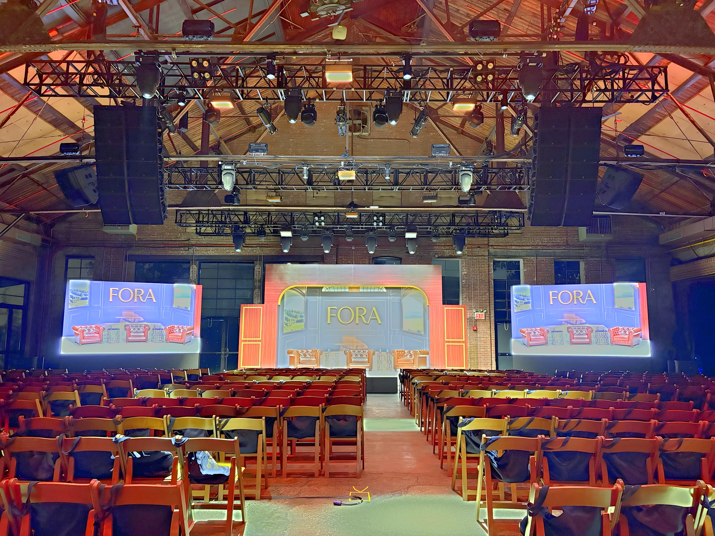 Fora conference at Knockdown Center with LUME LED wall visuals flanking the stage and rows of seating