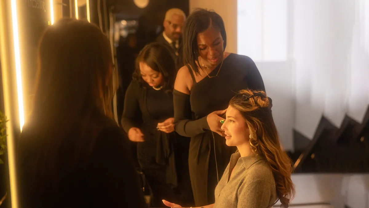 Stylist finishing a guest's updo at the TRESemme NYFW salon at LUME Studios