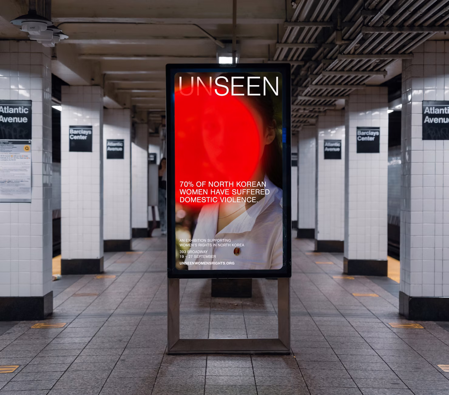 Subway platform ad for the Unseen exhibition on North Korean women's rights at 393 Broadway