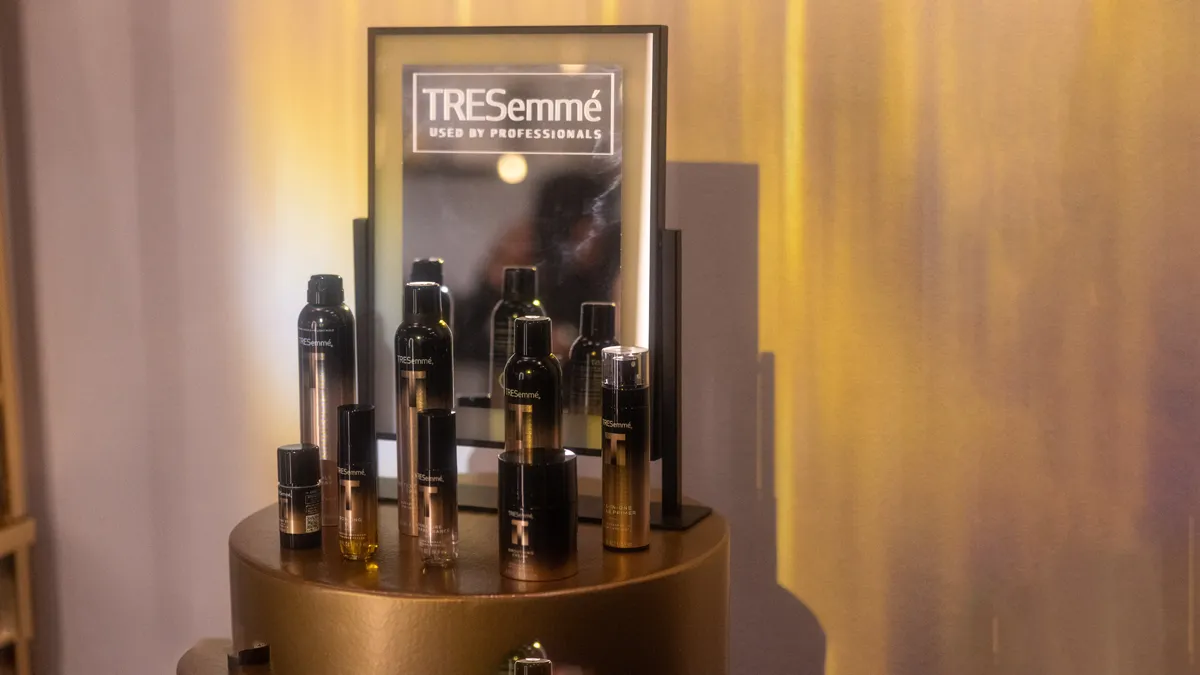 TRESemme product display on a gold pedestal at the TRESemme x NYFW event at LUME Studios