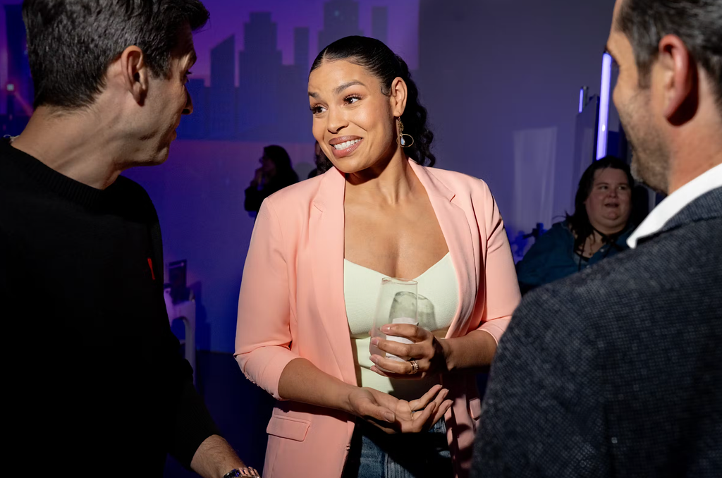 Guest in a pink blazer chatting at the Roku executive dinner at LUME Studios