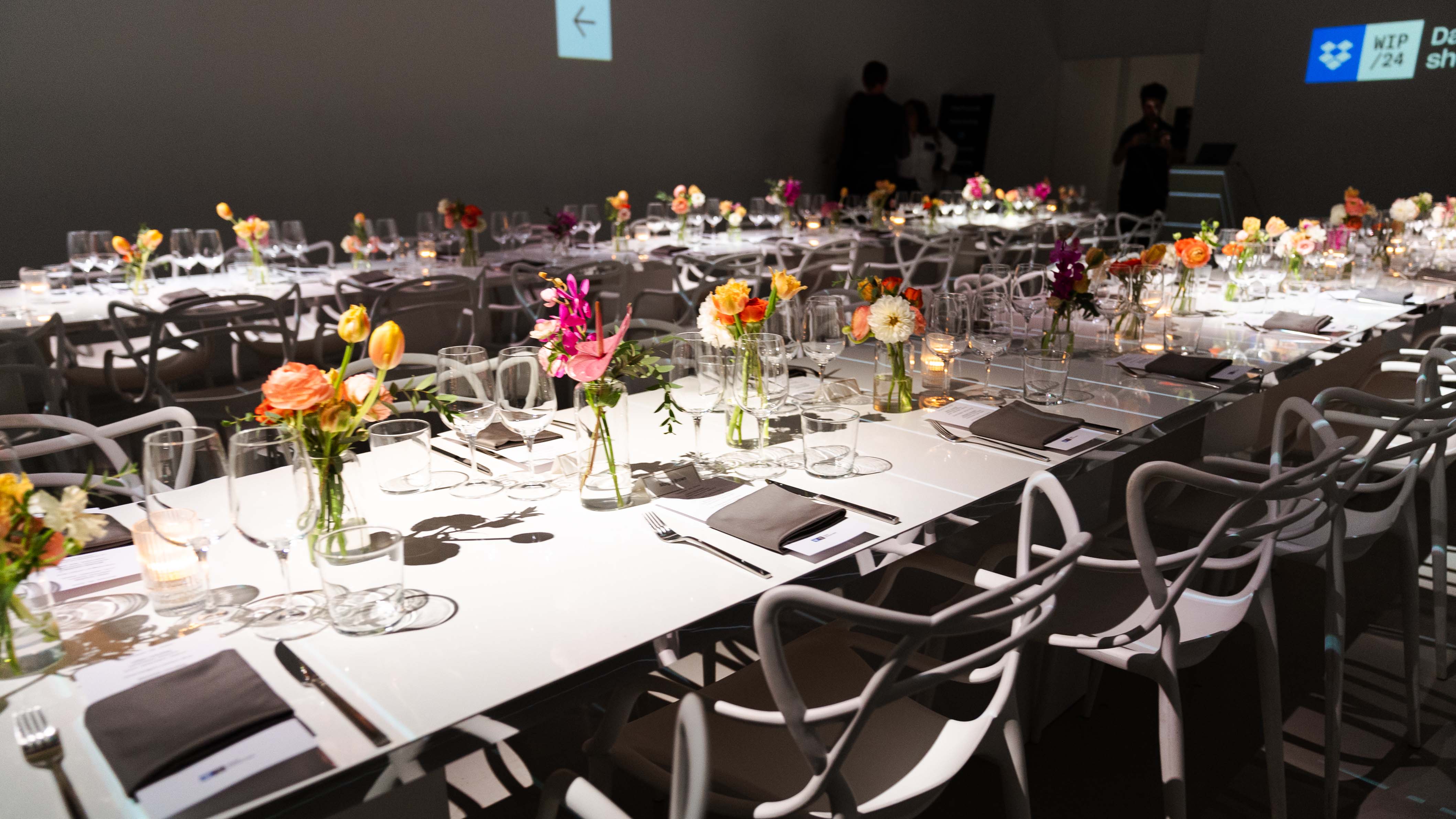 White dinner tables set with colorful flowers at the Dropbox dinner at LUME Studios