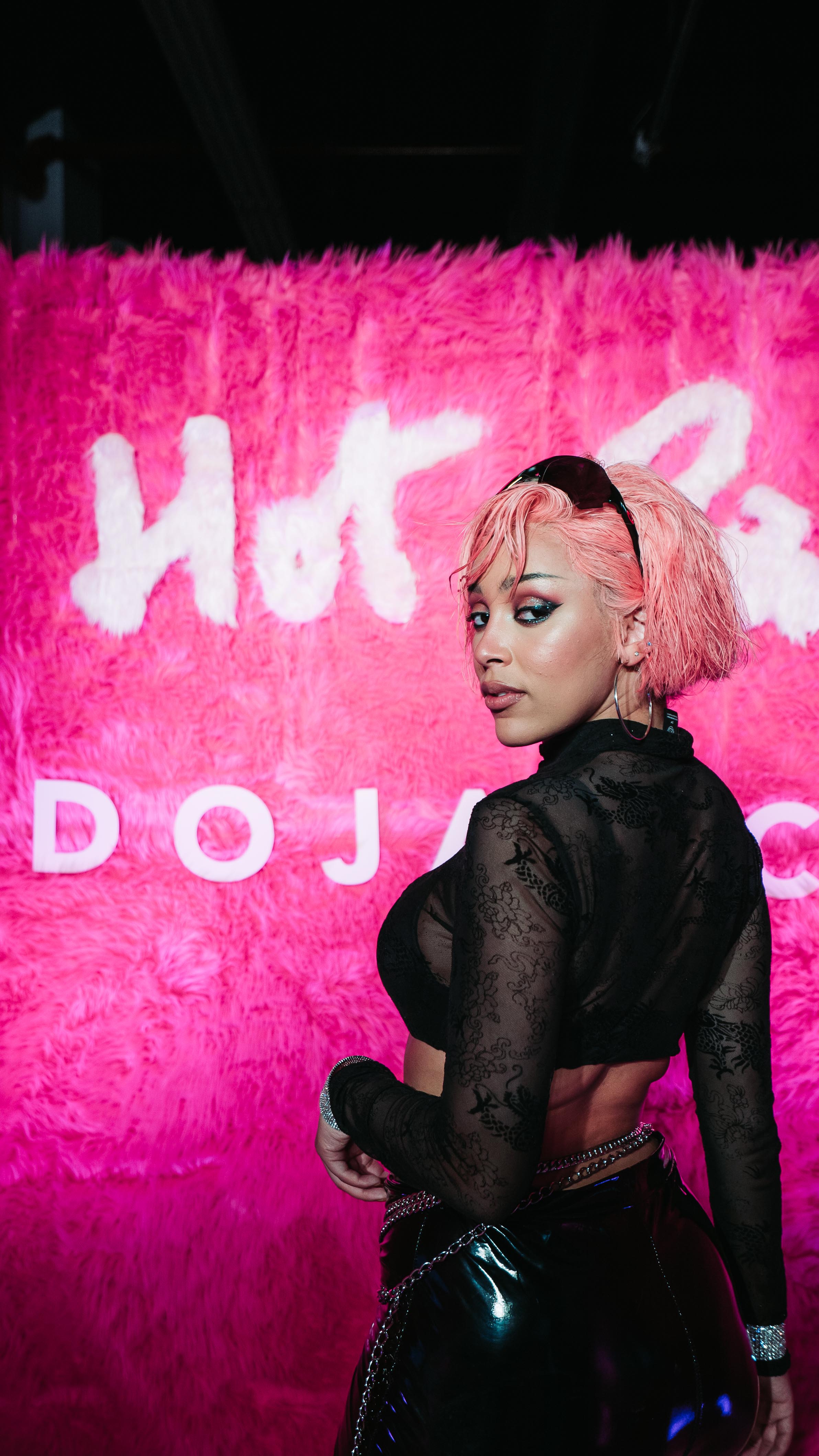 Doja Cat posing in front of a pink fur Hot Pink backdrop at LUME Studios