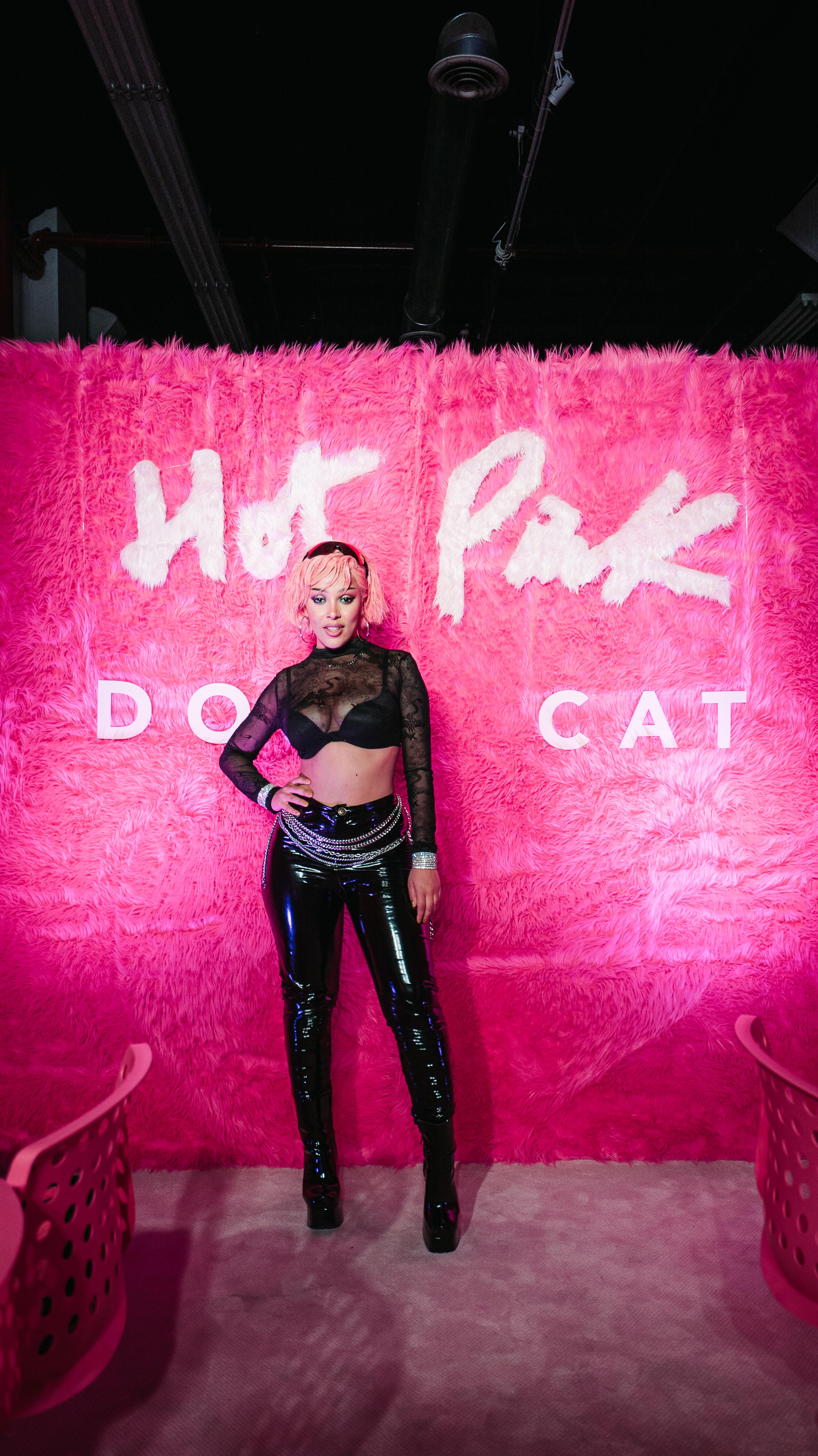 Doja Cat posing in front of a pink fur Hot Pink wall at LUME Studios