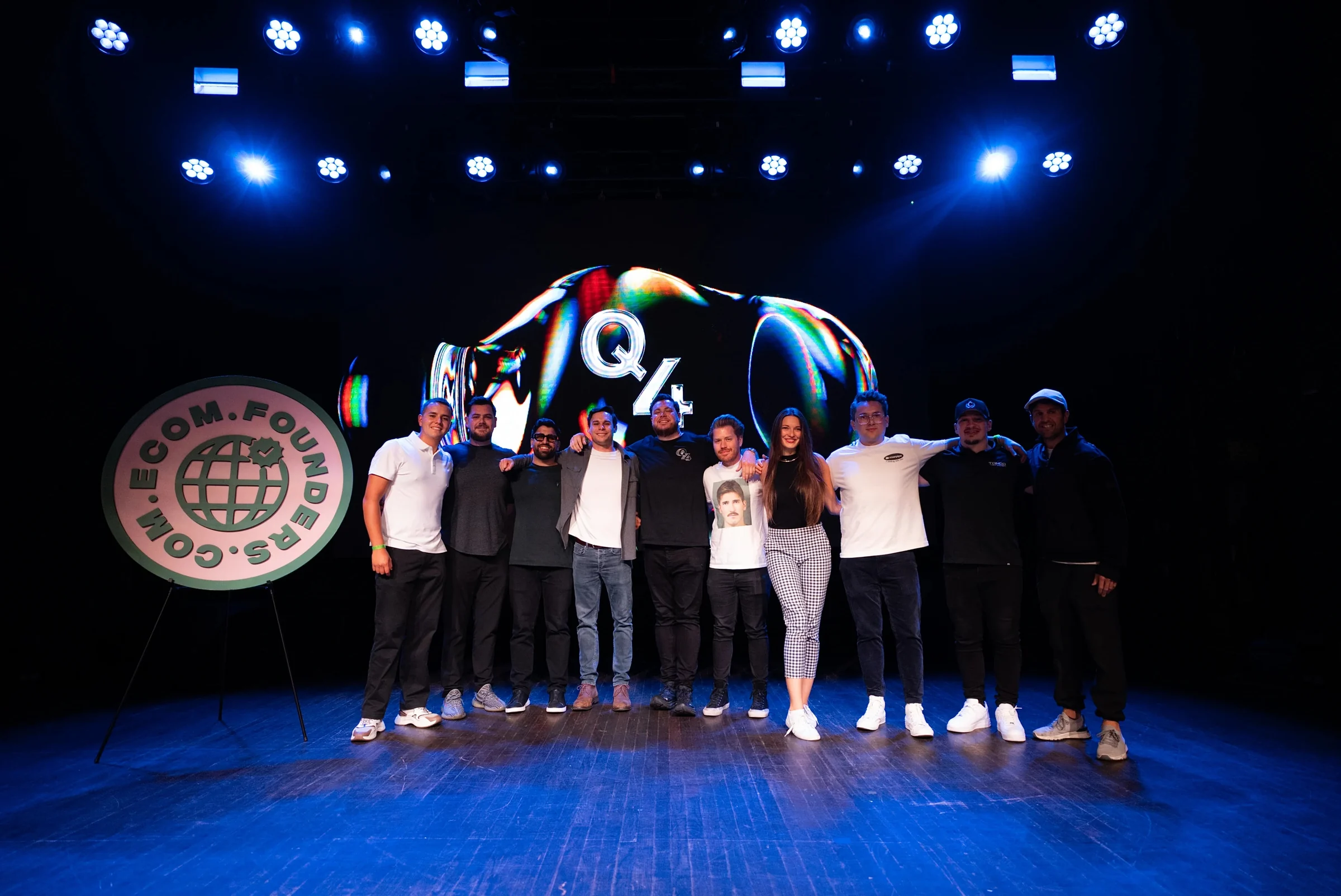 The Q4 Summit team together on the Webster Hall stage in front of the Q4 graphic on the LED wall.
