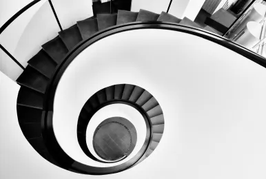 Black and white spiral staircase viewed from above, creating a circular pattern.