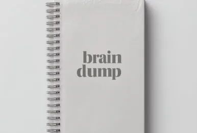 White spiral notebook with the words 'brain dump' printed in gray on the cover.