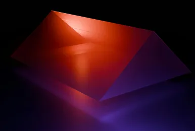 Abstract red and purple translucent pyramid-shaped object on a reflective surface with dark background.