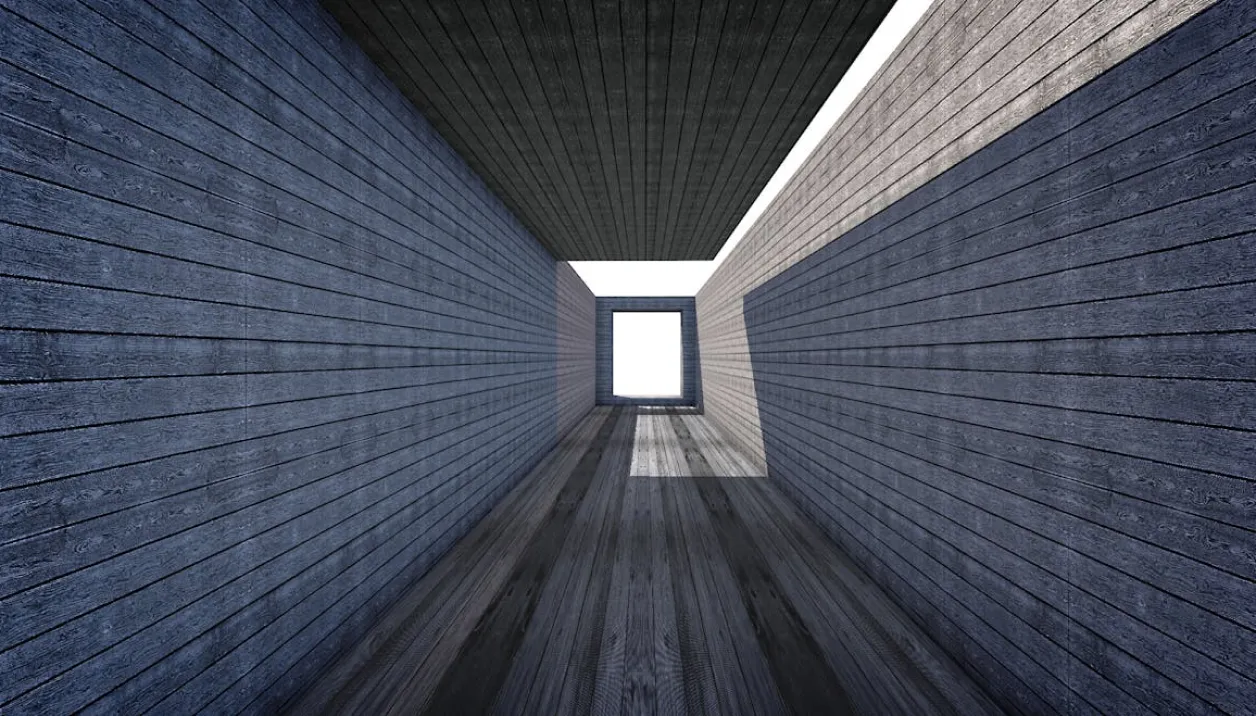 Perspective view inside a long, narrow wooden corridor with a rectangular opening at the far end letting in bright light.