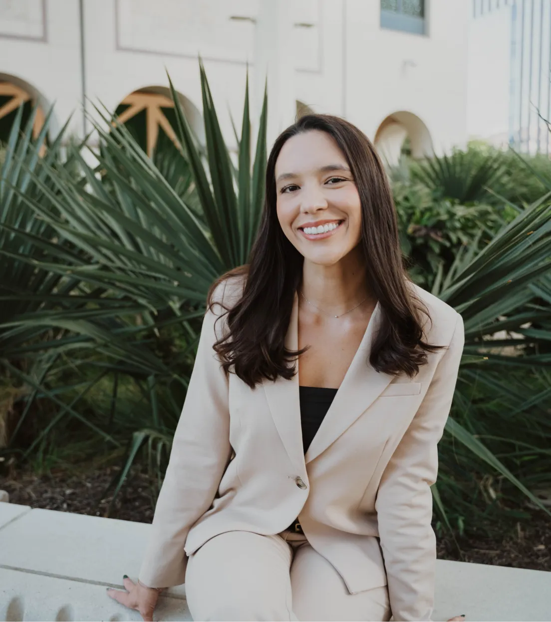 Dr. Emily Griffin Magee in a suit sitting on a ledge.