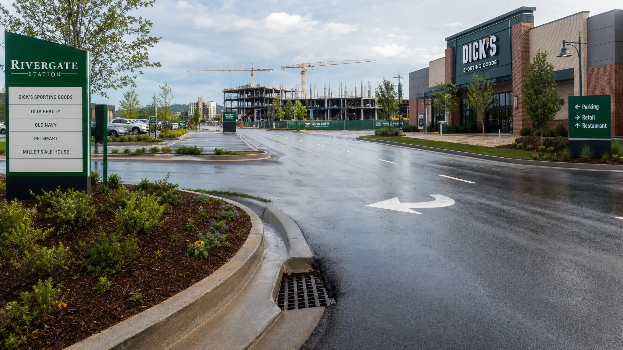 A commercial corridor near Nashville with swept parking areas, clean curb lines, active construction in the distance, and storm drains kept clear after recent traffic and rain.