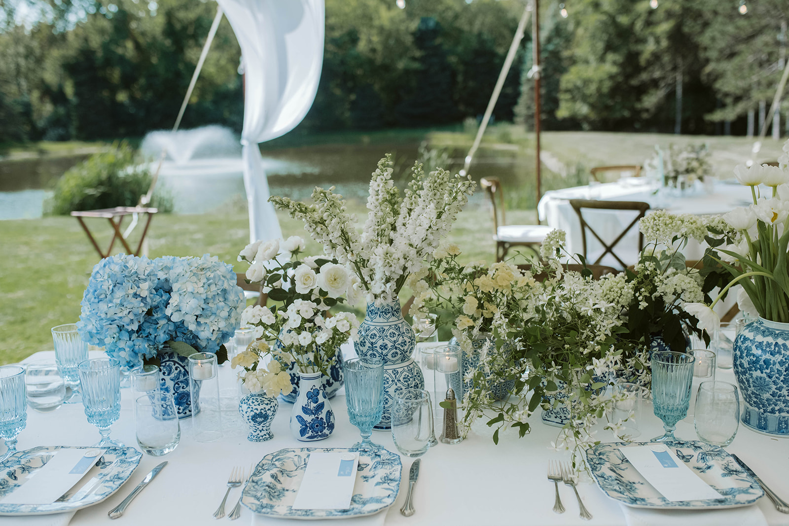 Outdoor wedding reception tablescape with blue hydrangeas and white florals at Belvedere Estate, Saugatuck Michigan