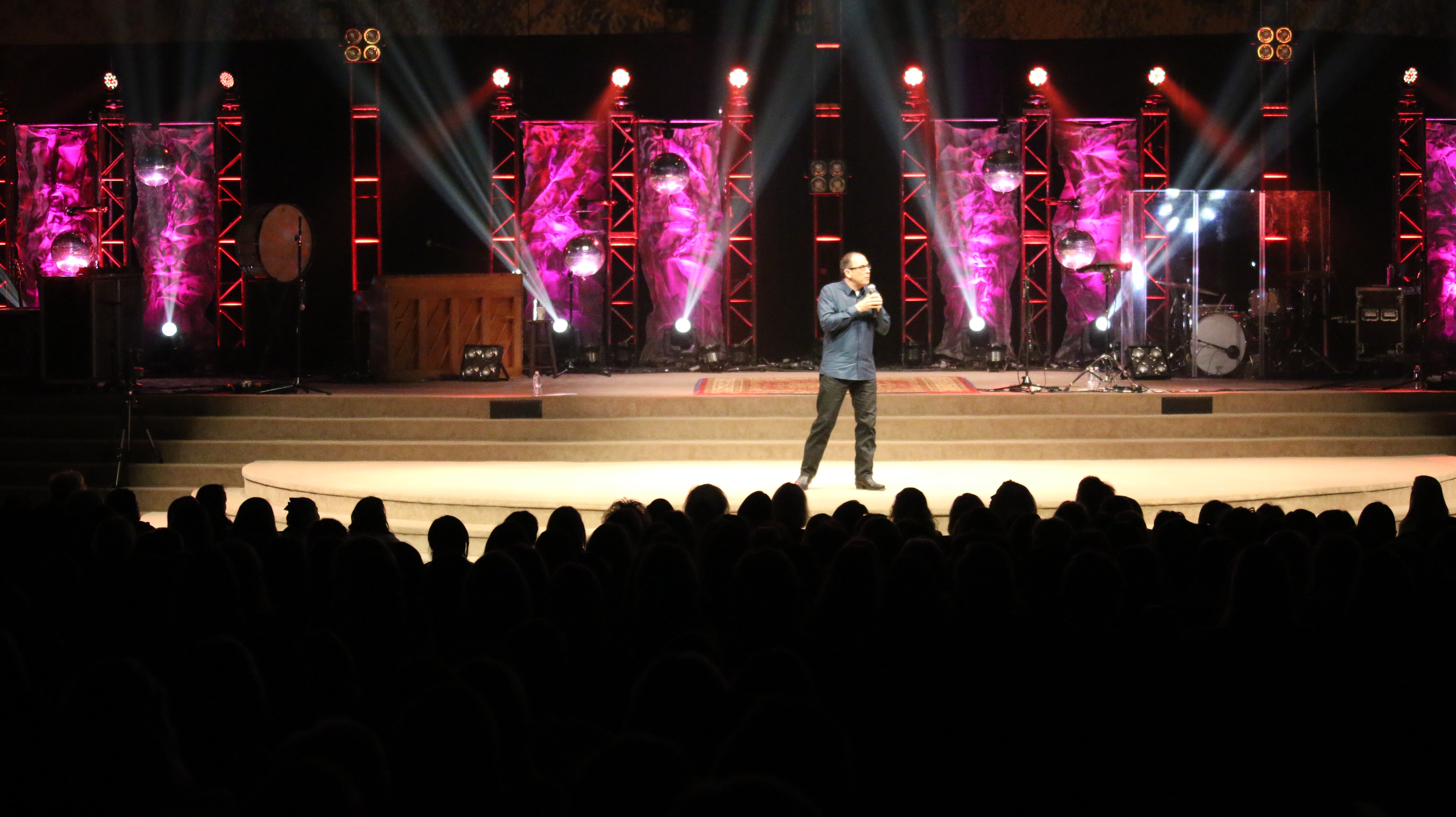 Nazareth performing standup comedy on stage under colorful lighting