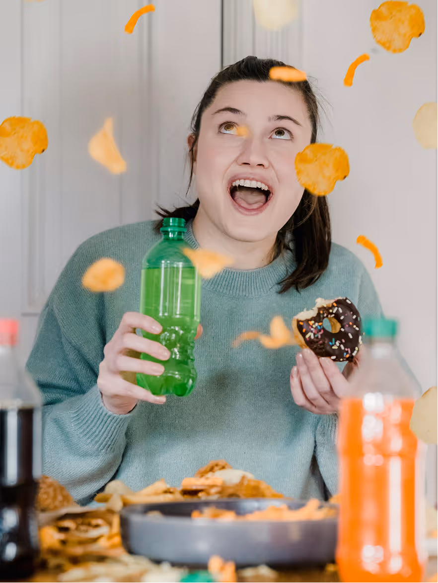 Person enjoying baked potato chips with a beverage.