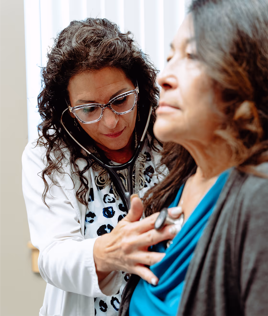 A mid-life Indigenous person receiving healthcare from an Indigenous doctor.