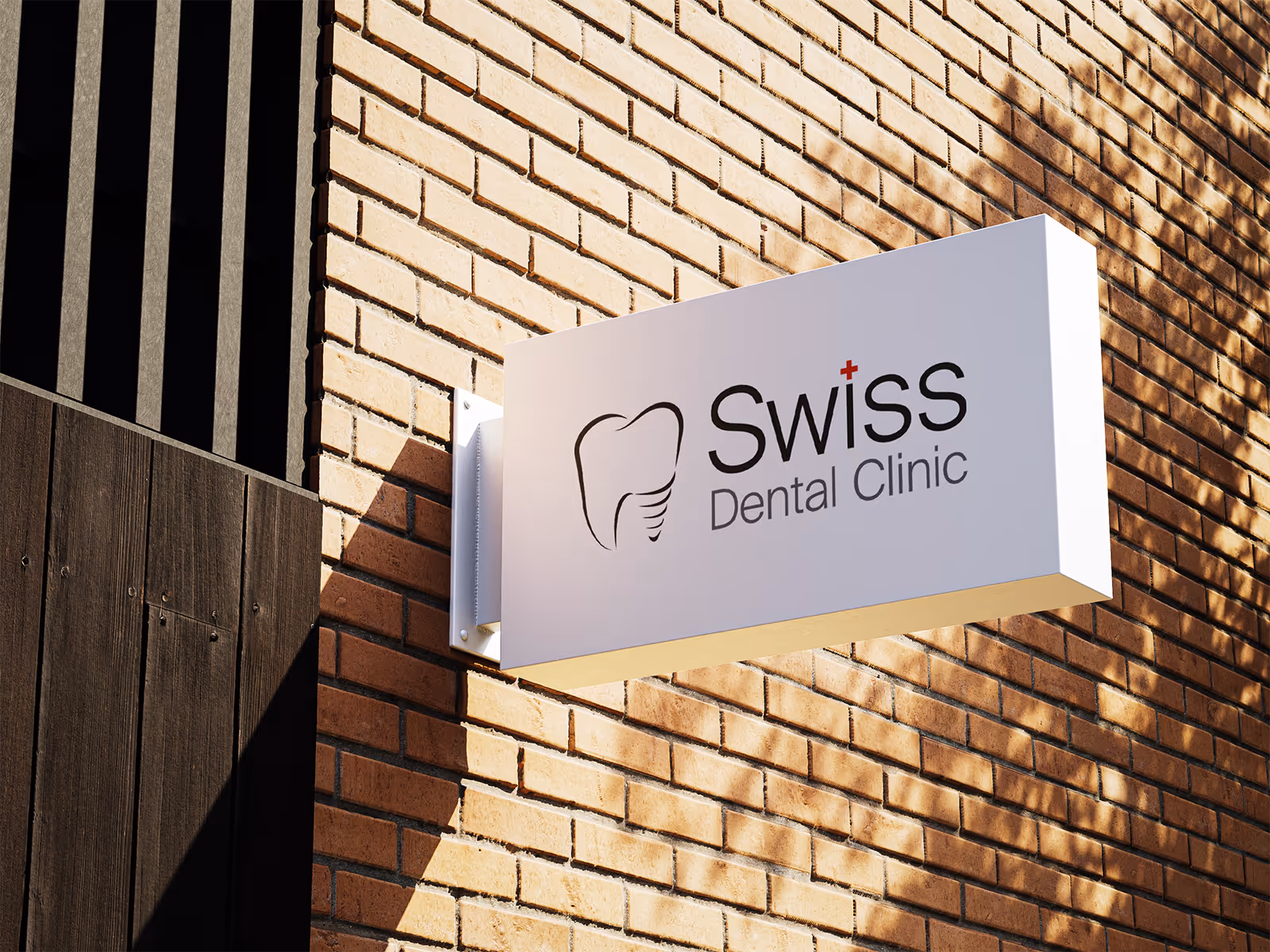 Rectangular white sign with a tooth icon and text 'Swiss Dental Clinic' mounted on a brick wall.
