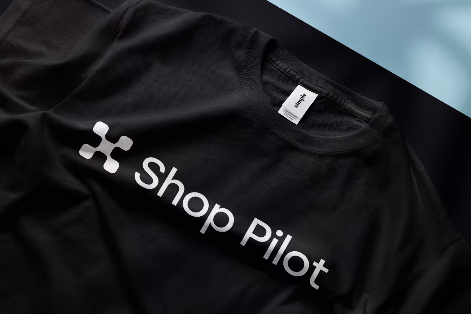 Black T-shirt with white Shop Pilot logo and text on the front.