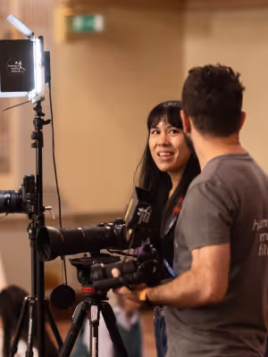 Two people working with professional camera and lighting equipment indoors.