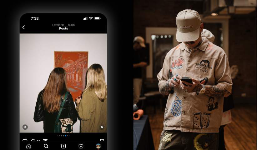 Man with tattoos and cap looking at his phone in a warmly lit room.