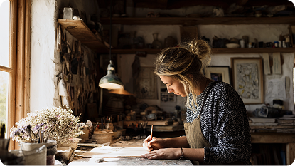 A woman painting at a desk