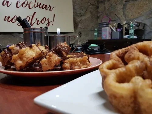 Una mesa de madera cubierta con platos de postres caseros elaborados en una clase de cocina.