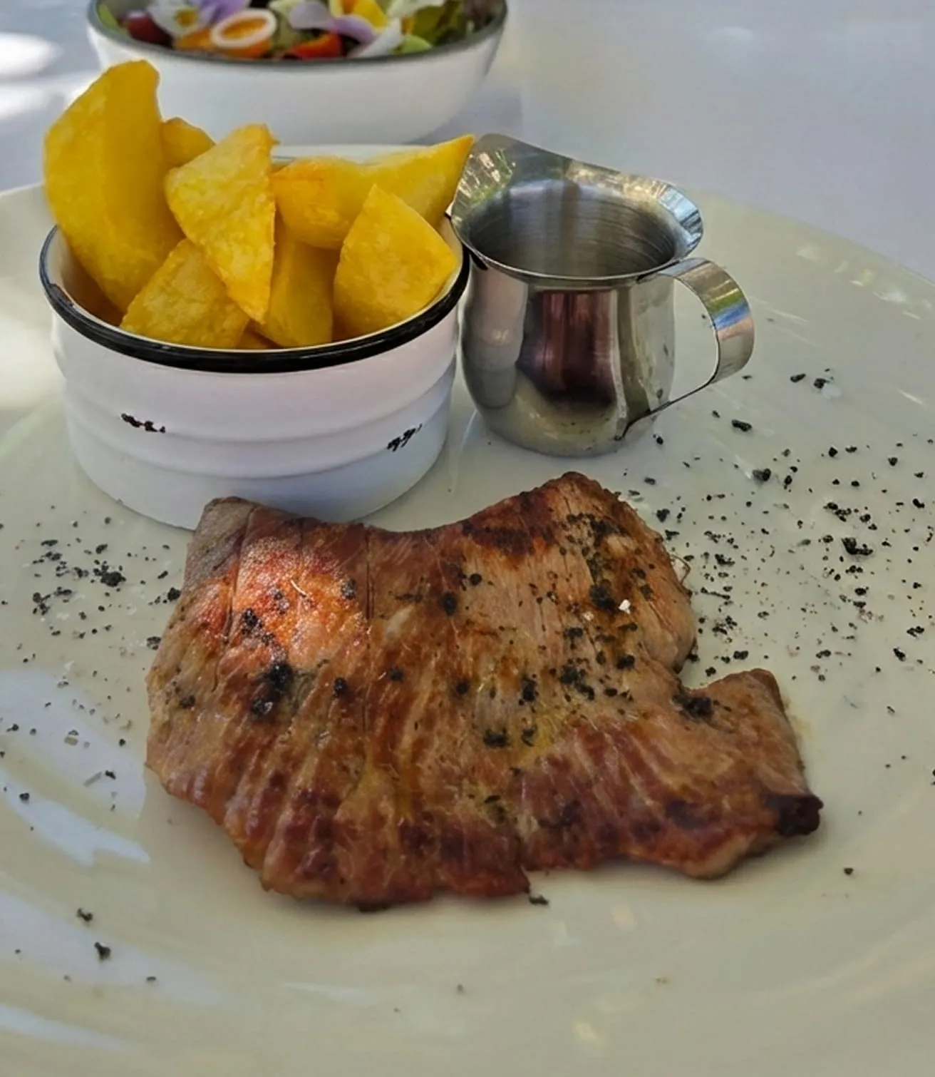Secreto de cerdo ibérico a la parrilla: corte jugoso asado de la brasa con patatas fritas.