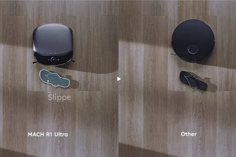 Top view comparison of two robotic vacuum cleaners on a wooden floor, labeled MACH R1 Ultra on the left and Other on the right, each next to a black slipper, with a spotlight highlighting the MACH R1 Ultra’s slipper.