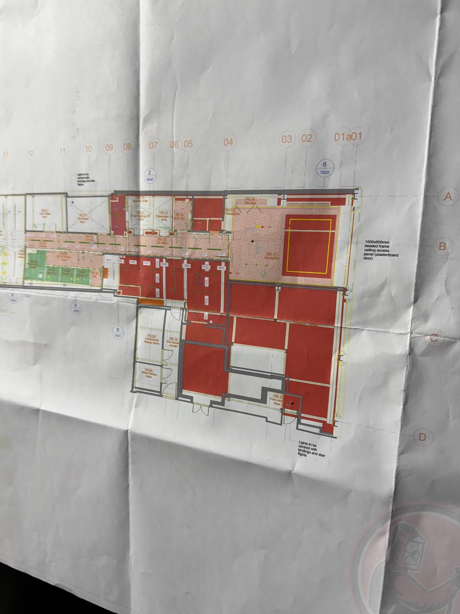 Folded architectural floor plan with labeled rooms, color-coded sections, and dimensions, featuring a staircase and ceiling access panel.